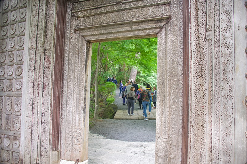 a group of people who have just walked thorugh a large entryway into a forest