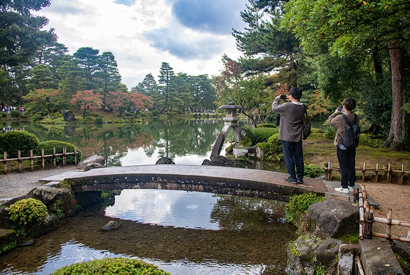 people taking photos of a beautiful park, one of the things to do in Japan