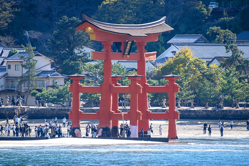 people visiting a huge Torii gate by the ocean, one of the things to do in Japan