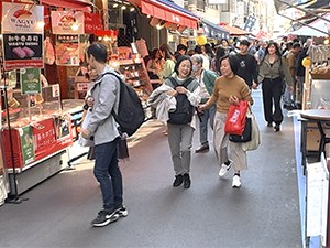 people walking along a colorful market street