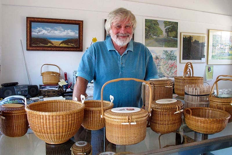 a man in a blue shirt with woven baskets