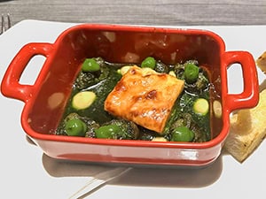 a red colored serving dish holding escargot