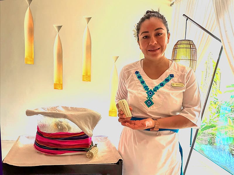 a masseuse holding a corn cob used in massages 