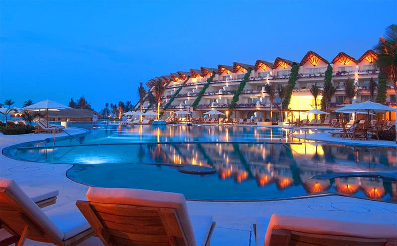 a hotel pool in the evening at the Grand Velas Riviera Maya Mexico