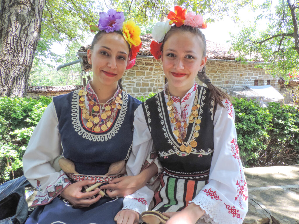 two young women in regional dress waiting to perform at a Eastern European festival