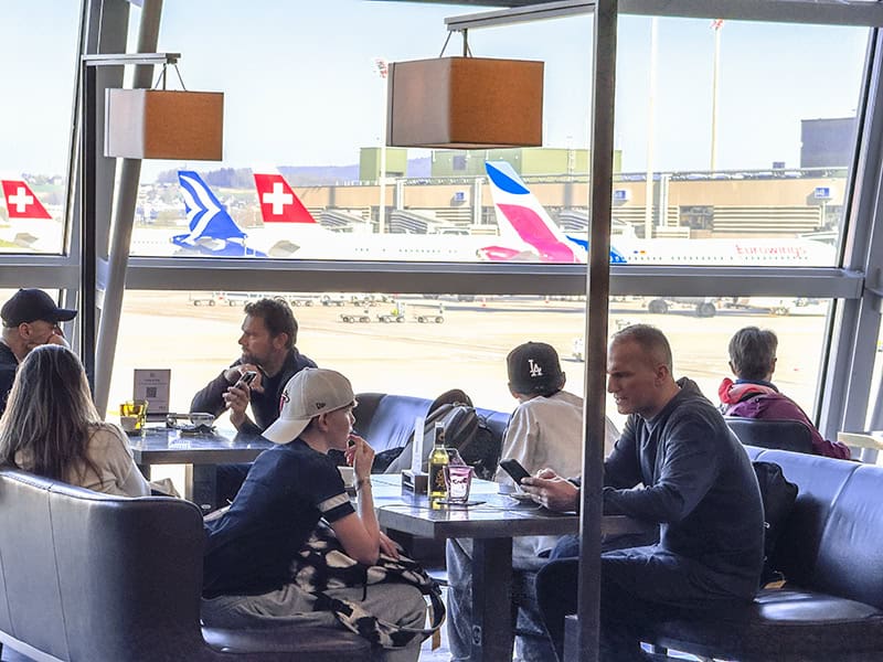 people sitting in an airport lounge awaiting a flight