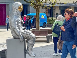 a woman looking at a statue of an astronaut 