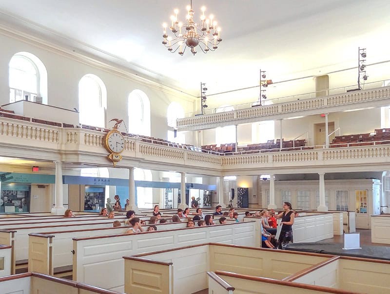 a teacher and her class in an old meeting house