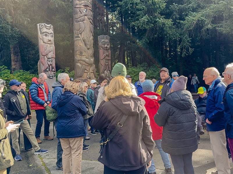 a crowd around 3 totem polevseen on a Silversea Silver Moon cruise