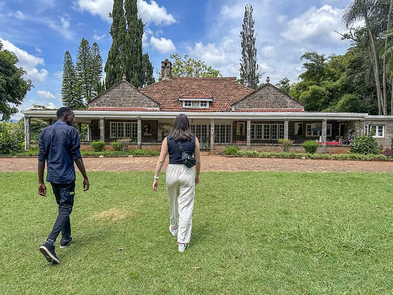 two people wsalking toward a large house