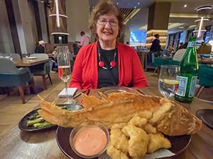 woman in red sweater at a table - review of atlantis bahamas