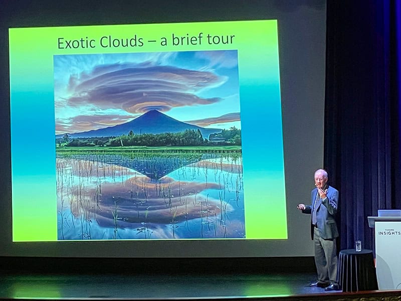 a lecturer by a screen showing exotic clouds on a Cunard queen Elizabeth Caribbean cruise 