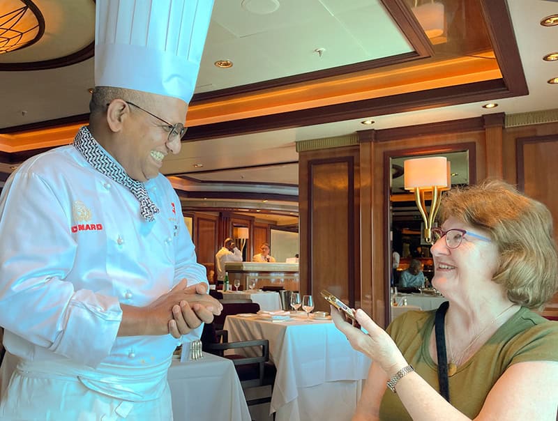 woman talking with a chef on a Cunard queen Elizabeth Caribbean cruise 